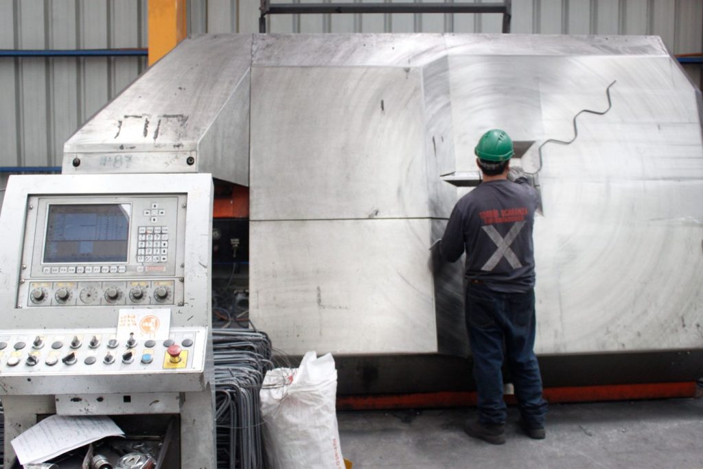 Operador trabajando en una máquina dobladora automática